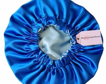 Può includere: Un cappello di raso blu con fodera blu chiaro. Il cappello ha un bordo arricciato e un'etichetta che recita "Bonita's Satin Bonnet".