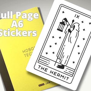 May include: A yellow notebook with the text "Full Page A6 Stickers" and a black and white tarot card featuring "The Hermit". The tarot card has a figure holding a lantern.