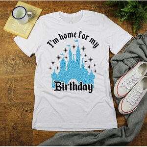 May include: White t-shirt with a blue glitter castle graphic and the text "I'm home for my Birthday".