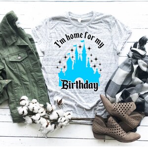 May include: A gray t-shirt with a blue castle graphic and the text "I'm home for my birthday".