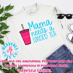 May include: A white long-sleeved shirt with the text "Mama needs a LOADED TEA" in blue and a pink and white cartoon image of a cup with a straw. The text "HEAVENSY CUTS co." is in a circle on the left side of the shirt. The text "Lines are for watermark Purposes only and Will not be inserted in Purchased file(s). *Layered Design." is at the bottom of the image.