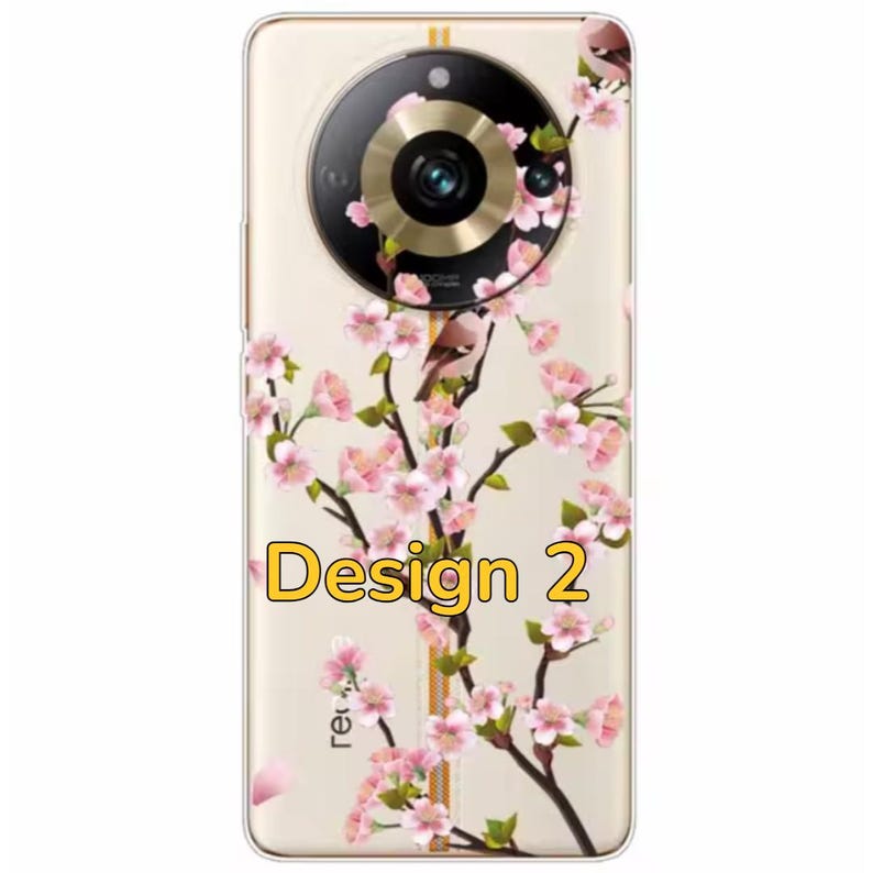 K&ouml;nnte beinhalten: Eine transparente Handyh&uuml;lle mit einem Blumendesign mit rosa Bl&uuml;ten und einem Vogel. Die H&uuml;lle hat einen goldenen Rand und einen runden Kameraausschnitt mit einem goldenen Ring. Der Text "Design 2" ist auf der H&uuml;lle aufgedruckt.