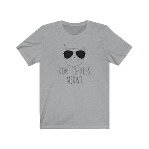May include: Gray t-shirt with a black and white illustration of a cat wearing sunglasses. The text "Don't Stress Meowt" is printed below the cat.