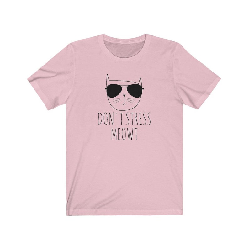 May include: Pink t-shirt with a black and white illustration of a cat wearing sunglasses and the text "Don't Stress Meowt"