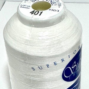 May include: A white spool of thread labeled "Superior Threads So Fine" with the number 401 and #50/3. The spool is made in Japan.