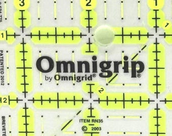 May include: A clear, yellow Omnigrip quilting ruler with black and yellow markings. The ruler features the text "Omnigrip by Omnigrid" and includes measurements and grid lines for precise cutting. The item is patented and dated 2012.