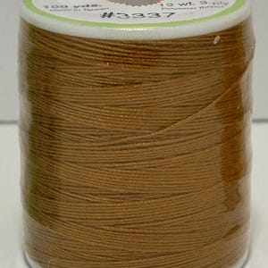 May include: A spool of brown sewing thread labeled "Sew Easy" with the text "100 yds. Made in Taiwan 12 wt. 3-ply Polyester thread #3337"