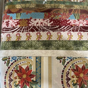 May include: A set of 10 fabric strips featuring a variety of Christmas-themed patterns, including snowflakes, candy canes, holly, and poinsettia designs. The fabric strips are in shades of red, green, gold, and white.