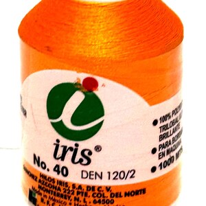 May include: Orange spool of Iris brand thread, No. 40, DEN 120/2. The label includes the Iris logo, text in Spanish, and details about the thread's composition and length, which is 1000 meters.
