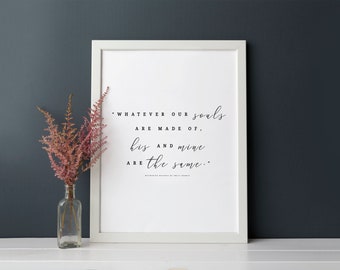 May include: A white framed wall art print featuring the black text: "Whatever our souls are made of, his and mine are the same." The quote is attributed to Wuthering Heights by Emily Brontë. A clear glass bottle holds pink dried flowers.