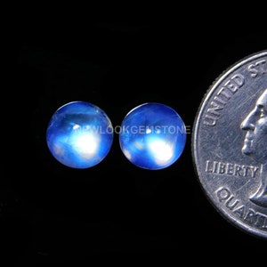 May include: Two round blue moonstone cabochons, each approximately the size of a US quarter.