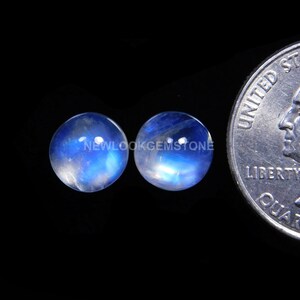 May include: Two round, iridescent blue moonstone cabochons, each approximately the size of a US quarter.