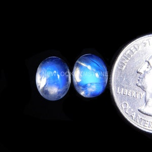 May include: Two round, blue moonstone cabochons, each approximately the size of a US quarter.