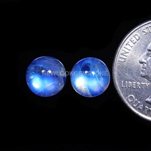 May include: Two round blue moonstone cabochons, each approximately the size of a US quarter.