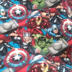 Op de afbeelding: Een kleurrijke stof met verschillende Marvel-superhelden, waaronder Captain America, Iron Man, Thor, Hulk en Black Widow. De stof is blauw met rode, gele en groene accenten.