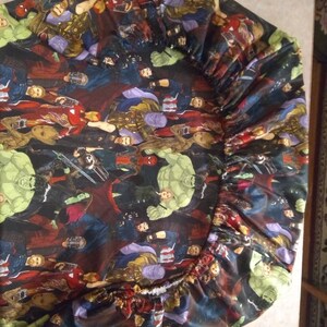 Op de afbeelding: Een zwart hoeslaken met een kleurrijke print van verschillende Marvel-superhelden, waaronder Hulk, Iron Man, Thor en Captain America.