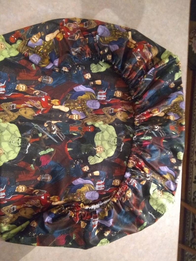 Op de afbeelding: Een zwart hoeslaken met een kleurrijke print van verschillende Marvel-superhelden, waaronder Hulk, Iron Man, Thor en Captain America.