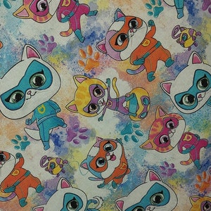 Peut inclure: Un motif de tissu avec des chats de dessins animés en super-héros dans diverses poses. Les chats sont de couleurs orange, rose, bleu et jaune, avec des masques blancs et des costumes de super-héros. Des empreintes de pattes et des éclaboussures de peinture colorées complètent le motif.
