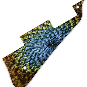 May include: A guitar pick with a close-up image of a sunflower's center. The center is a swirling pattern of blue, yellow, and brown.