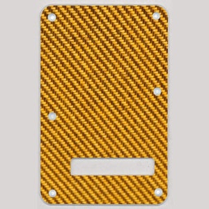 May include: A gold and black guitar pickguard with a woven pattern. The pickguard has a rectangular shape with rounded corners and a cutout for a control knob.