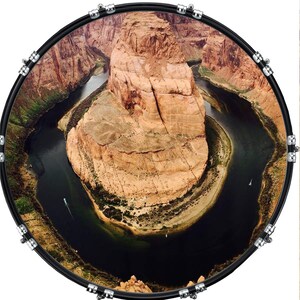 May include: A black bass drum with a photo of a horseshoe bend in the Colorado River. The photo shows a large rock formation with a river winding around it.