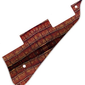 May include: A brown guitar pickguard with a crocodile skin pattern.