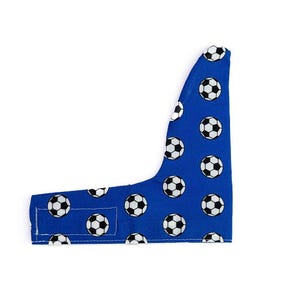 Puede incluir: Un accesorio de tela azul con un patrón repetitivo de balones de fútbol en blanco y negro. El artículo tiene una forma asimétrica y curva con una lengüeta rectangular en la esquina inferior izquierda, acabado con costuras blancas visibles.