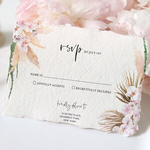 Pode incluir: Cart&atilde;o RSVP com borda rasgada, com desenhos florais em aquarela em rosa, bege e verde. O cart&atilde;o inclui o texto "RSVP", "By July 1st" e detalhes do endere&ccedil;o. O cart&atilde;o &eacute; projetado para um casamento ou evento especial.