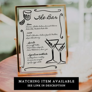 Puede incluir: Un cartel con marco dorado, fondo blanco y texto negro que dice "The Bar". El cartel enumera diferentes tipos de cerveza, vino, licores y c&oacute;cteles de autor.