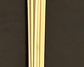 May include: A wooden stick with a black and red braided handle. The stick is made up of multiple thin wooden rods bundled together.