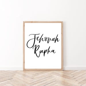 Puede incluir: Una impresión enmarcada con el texto "Jehovah Rapha" en caligrafía negra sobre fondo blanco.