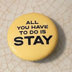 May include: Yellow button with black text that reads "ALL YOU HAVE TO DO IS STAY".