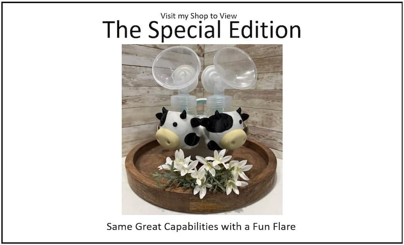 K&ouml;nnte beinhalten: The Special Edition Milchpumpe mit Kuh-Akzenten. Die Pumpe hat transparente Flaschen und steht auf einem Holztablett mit wei&szlig;en Blumen. Der Text "Same Great Capabilities with a Fun Flare" ist sichtbar.