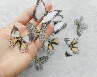 May include: Assortment of handmade fabric butterflies with black and white wings and yellow accents. Each butterfly has a clear rhinestone in the center.