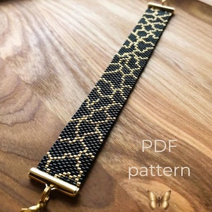 May include: A beaded bracelet featuring a black and gold geometric pattern. The bracelet has gold-toned metal end caps and a lobster clasp. The text PDF pattern is visible in the lower right corner, accompanied by a small gold butterfly icon.