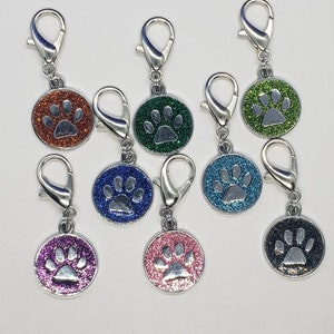 May include: Assortment of ten silver keychains with glitter paw print charms in various colors, including orange, green, blue, purple, pink, and black.