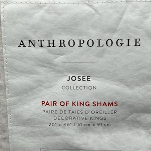 May include: A white label with the text "ANTHROPOLOGIE" at the top. Below, it reads "JOSEE COLLECTION" and "PAIR OF KING SHAMS". The dimensions are listed as 20" x 36" (51 cm x 91 cm).