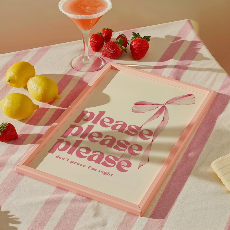 May include: Pink framed print with the text "please please please don't prove I'm right" in pink lettering. A pink ribbon is in the background.