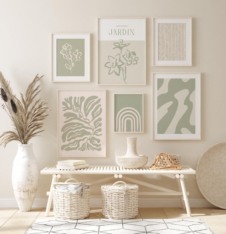 May include: A white bench with two white wicker baskets underneath. There are six framed prints on the wall behind the bench. The prints feature abstract designs in shades of green and white. The text "GALERIE JARDIN" is visible on one of the prints.