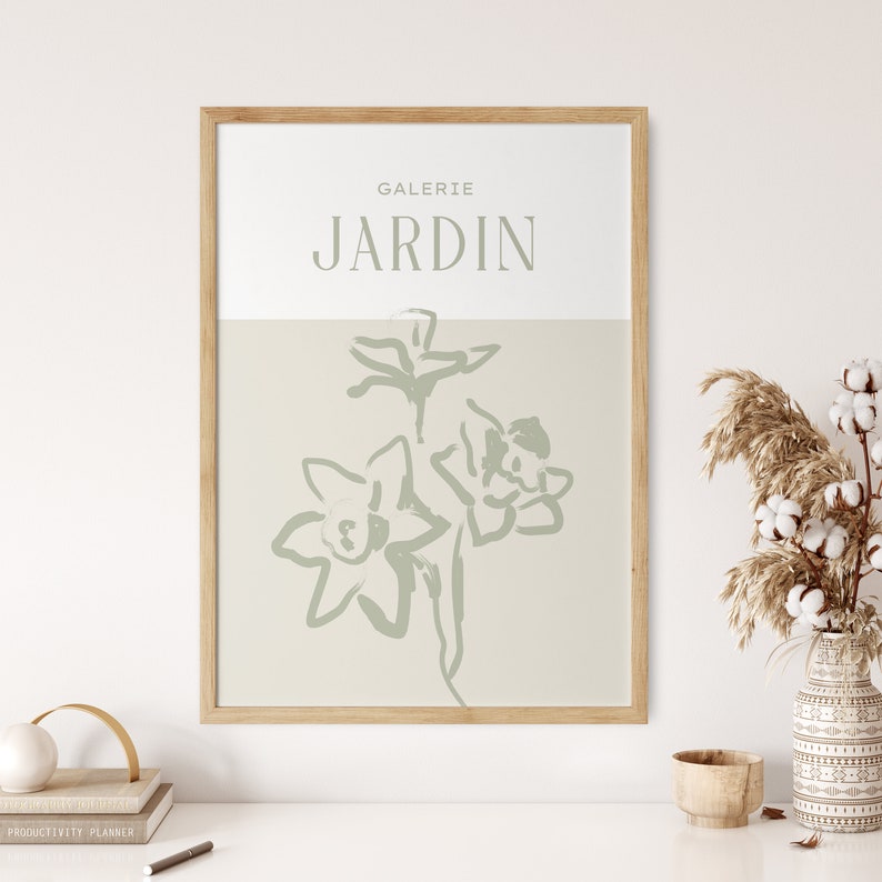 May include: A framed print with a light green floral illustration and the text "GALERIE JARDIN" in a light brown frame.