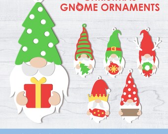 Puede incluir: Una colección de adornos navideños de gnomos en varios diseños. Los adornos presentan colores verde, rojo, blanco y beige. El texto "CHRISTMAS GNOME ORNAMENTS" se muestra en la parte superior. La parte inferior de la imagen muestra "SVG/PNG/DXF/EPS/AI".