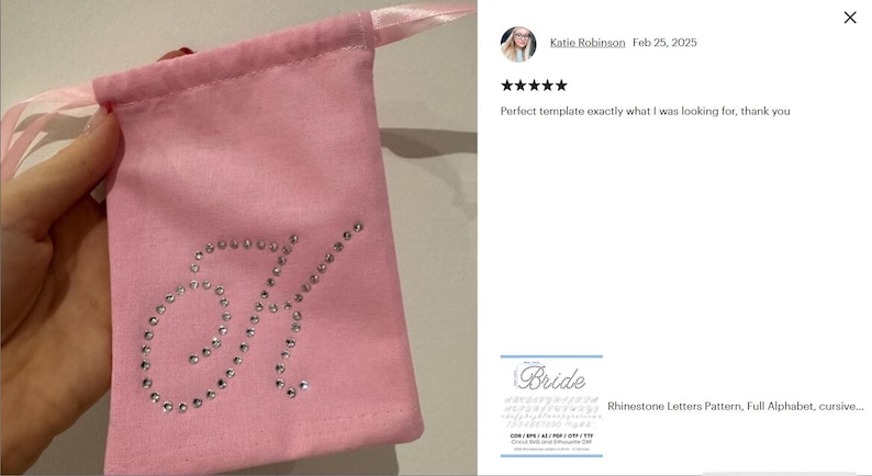 May include: A light pink fabric drawstring pouch featuring a large, cursive letter K embellished with clear, sparkling rhinestones. The pouch has a matching light pink satin ribbon closure at the top, providing a secure way to cinch the bag closed.