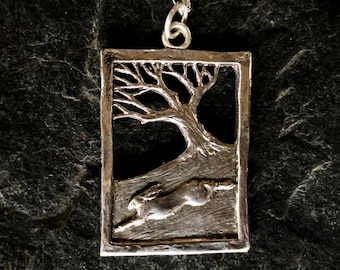 Hare running through wood pendant  necklace in silver .