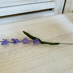 May include: A single stem of purple felt lavender with green felt leaves.