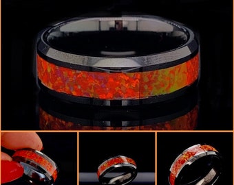May include: A black tungsten carbide ring with a red and orange opal inlay. The ring has a beveled edge and a polished finish.