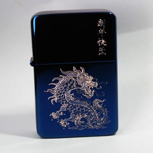 May include: A blue metal lighter with a gold dragon design and the text "新年快乐" in gold lettering.