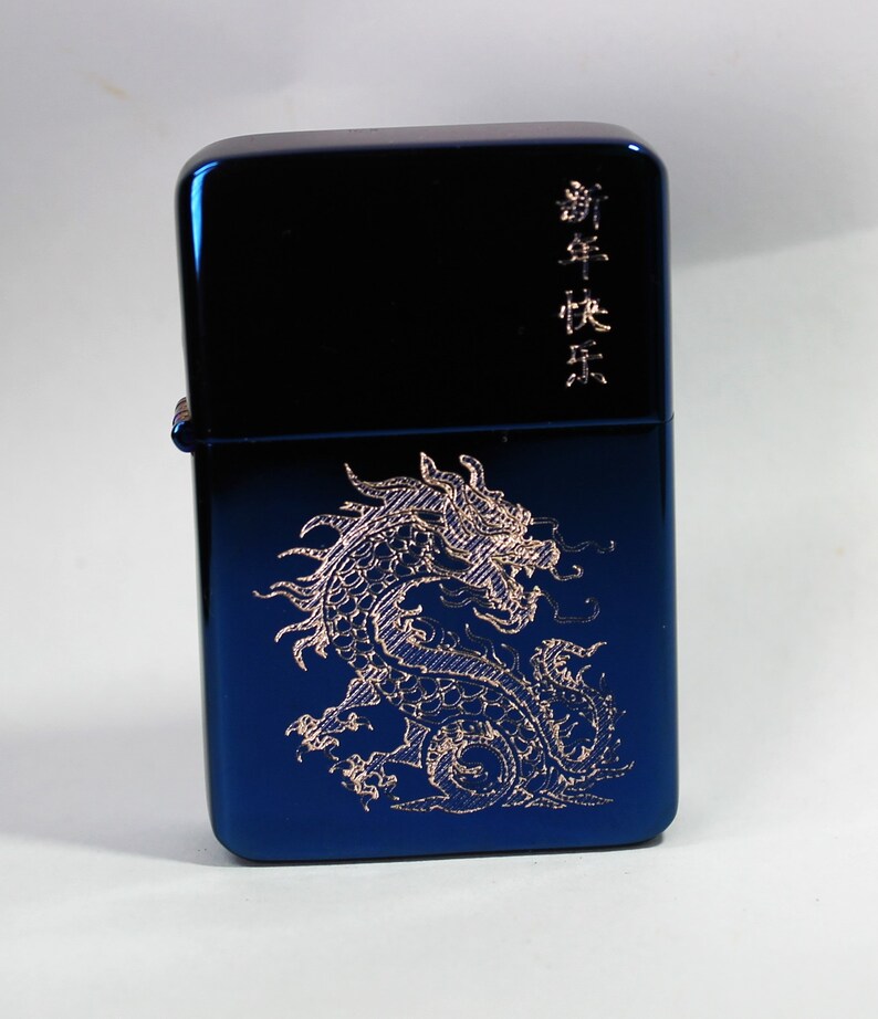 May include: A blue metal lighter with a gold dragon design and the text "新年快乐" in gold lettering.