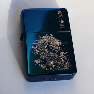 May include: A blue lighter with a gold dragon design and the text "龍年大吉" in gold lettering.