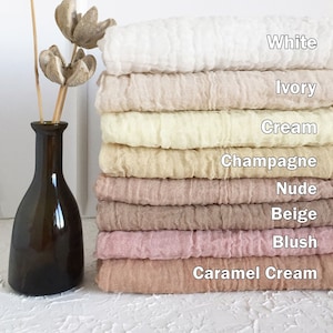 May include: A stack of ten fabric squares in various shades of beige, cream, and pink. The squares are labeled with the following colors: White, Ivory, Cream, Champagne, Nude, Beige, Blush, and Caramel Cream.