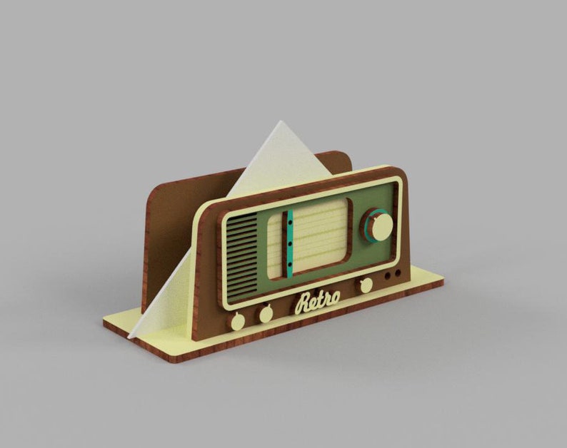 May include: A wooden napkin holder shaped like a vintage radio. The radio is brown with a green front panel and a white paper napkin inside. The radio has a dial with the word "Retro" on it.